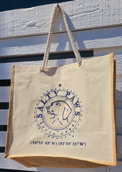 Our custom-branded Salty Paws Canvas Tote Bag is perfect for shopping trips, errands, or any adventure under the sun. With burlap sides, rope handles, and the iconic Salty Paws Punta Gorda logo, it's as stylish as it is practical. Get yours today and carry a piece of coastal charm wherever you go! This bag is best used for dry goods only. If the bag gets wet be sure to air dry due to natural element of burlap sides.